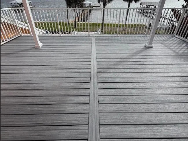 New composite deck with white railings overlooking the water and palm trees