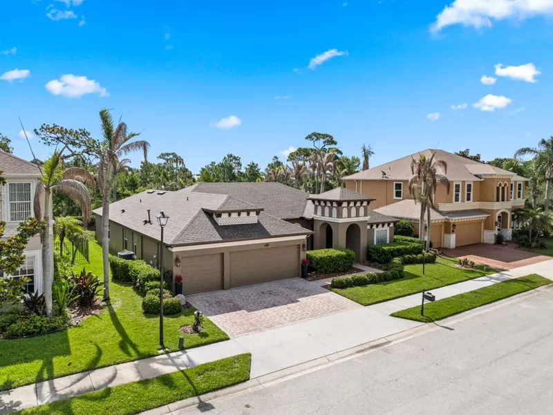 Aerial view of a coastal neighbourhood with new tile and shingle roofs among palm trees