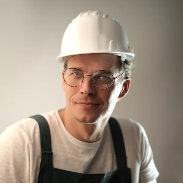 Portrait of a man in a white hard hat and glasses